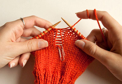 An example of knitting (red), with two needles. 