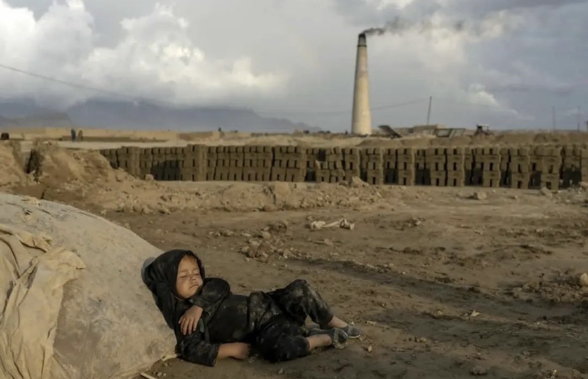 A 4-year old Afghan girl rests after working in a bricklaying factory.