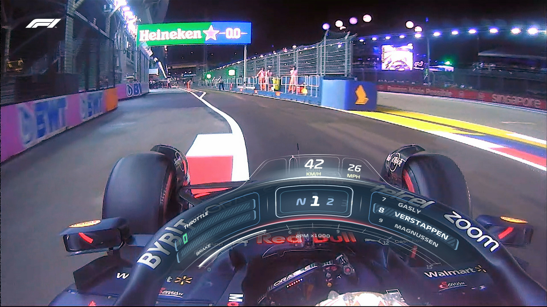 An onboard camera angle of Max Verstappen driving in his Red Bull. He is seen entering the pit lane, with the open racetrack to his right