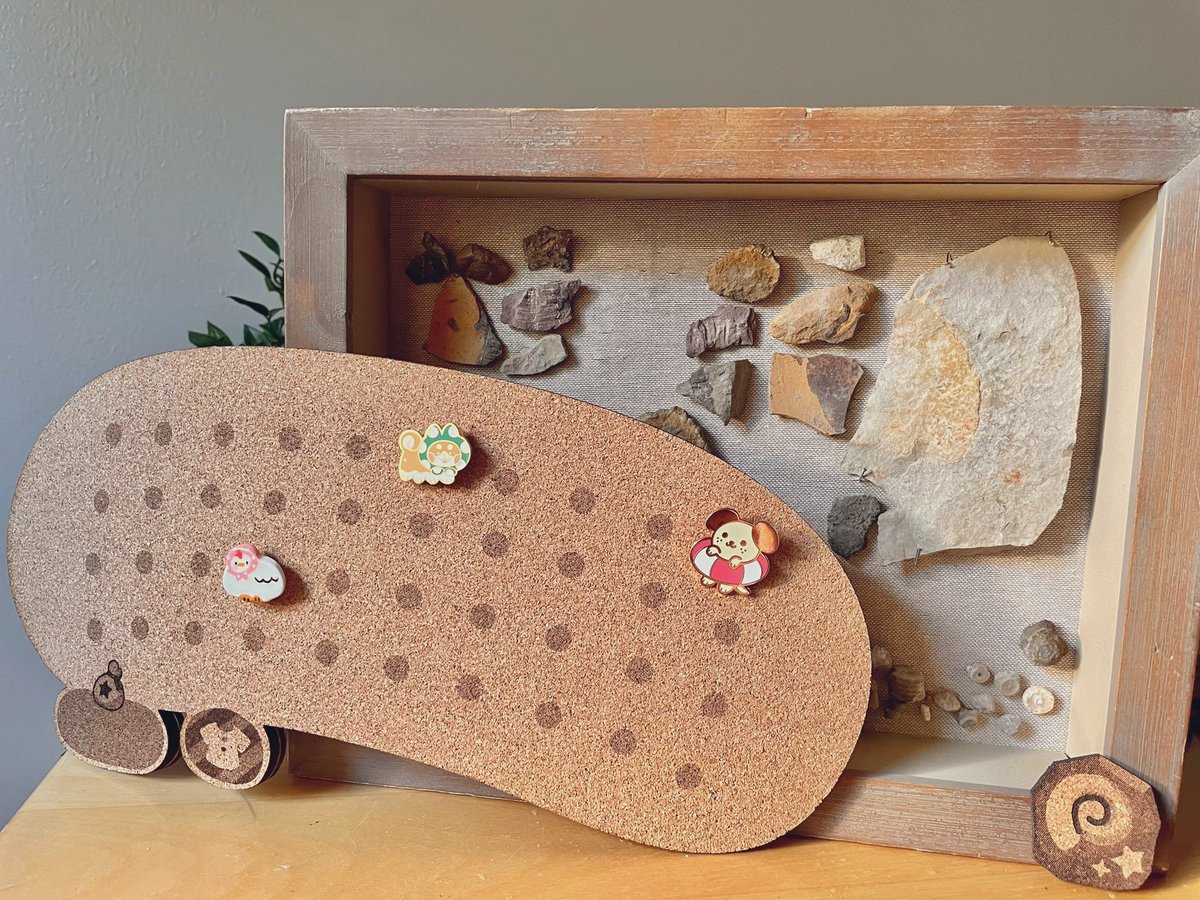 fawnesty's tweet photo. I’ve never seen an Animal Crossing inventory cork board and really wanted one to put my pins on. So I designed and lasered one today. I also drew vectors of unidentified fossils and leaves. Pins by @crapmachine @BreeLundberg https://t.co/FLTGuWr0Bf