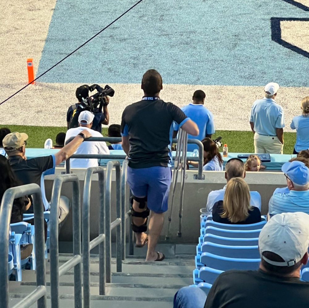 The definition of fandom. A dedicated #UNC fan with a completely torn ACL, MCL, PCL, and meniscus stands with crutches in hand and brace on knee, on the rim of the Blue Zone to watch Carolina vs. Notre Dame on Saturday. Blue zone? More like blue collar.