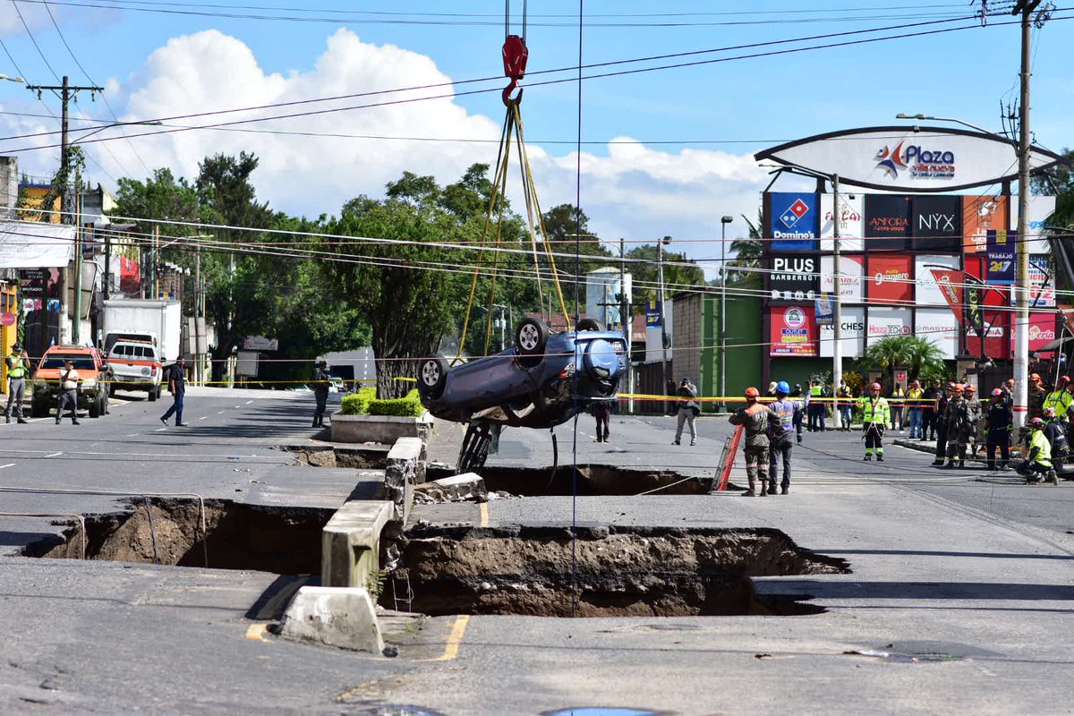 Uno de los vehículos que se precipitó en el nuevo hundimiento de Villa Nueva, es recuperado por agentes de la PMT de Villa Nueva en conjunto con socorristas, personal de Covial y Ejército.