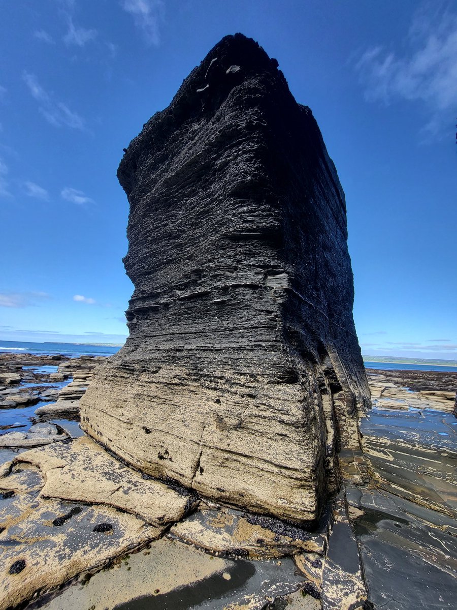 A stack of sandstone and shale layers cut off, by coastal erosion, and standing apart from the rest of the Cliffs, County Clare, Ireland.