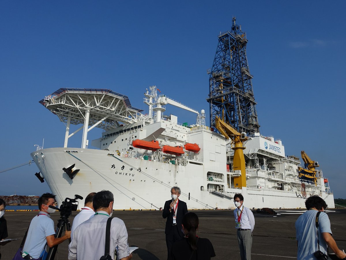 新潟県上越市の直江津港。
記者に囲まれる研究者の背後に見えるのは…！

海洋研究開発機構の地球深部探査船「ちきゅう」です。
表層型メタンハイドレートの研究の一環で、産総研が調査航海を行うことに。
上越市の協力のもと、出航前の9/16（金）に地元メディアへの説明をしてきました。