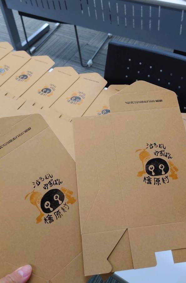 本日はパッケージ制作風景のご紹介です🎁

今年度はゆずぼんのスタンプを手作業で1つずつ挿入しました🎨
手作業ならではの温かみがポイントです🍊

新ゆずぼんは今秋発売予定です！
秋の夜長に、ぜひゆずワイン香るチョコレートはいかがですか🍸🍫

#檜原村 #中央大学 
#ゆずぼん #泣きむしゆずぼん