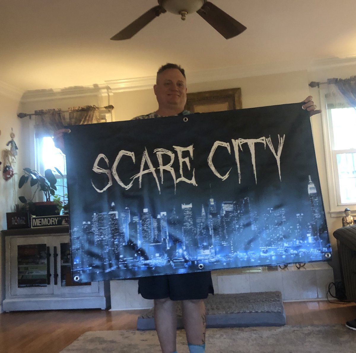 leahhgood's tweet photo. every year my sweet halloween obsessed father designs an elaborate skeleton tableau. it covers the whole yard. he unveiled this year’s theme with a custom flag 🖤🧡🧻🌃 https://t.co/QbYy3tVAtW