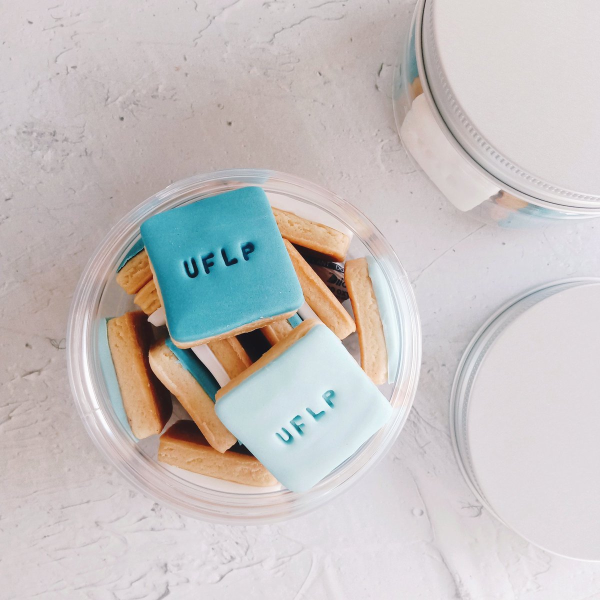 s_kiv13's tweet photo. custom gift request for some company event #nomention minis square vanilla cookies with fondant icing UFLP stamp on top 💙 #bakingdaily #icingcookies https://t.co/VXrQ5oe0MJ