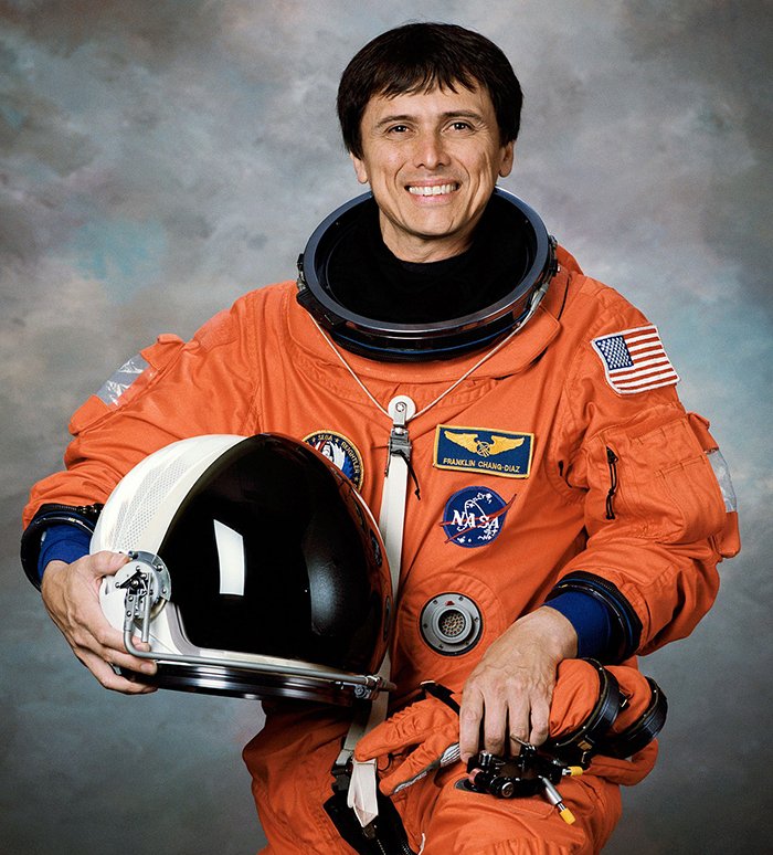 Franklin Chang-Díaz's NASA picture. He is wearing an orange spacesuit and holding a helmet in his right arm.