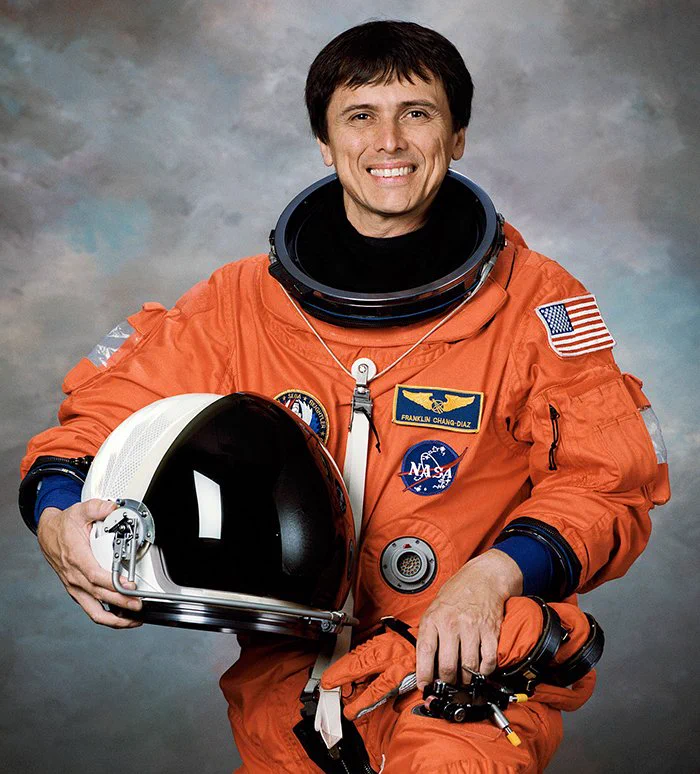Franklin Chang-Díaz's NASA picture. He is wearing an orange spacesuit and holding a helmet in his right arm.