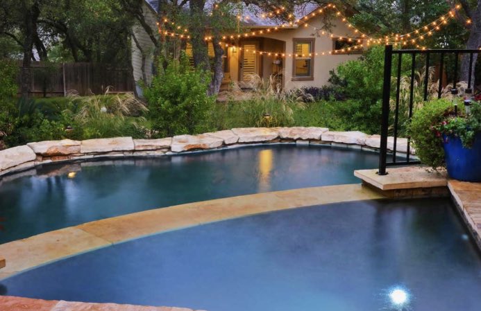 Lagoon-style pool with lush greenery gives vibes of a natural habitat. #AustinPoolBuilders #AustinSwimmingPools #ReliantPools