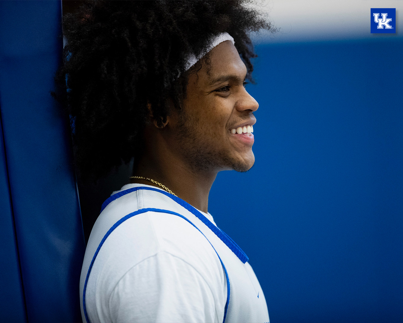 Sahvir Wheeler smiles while leaning up against basketball goal