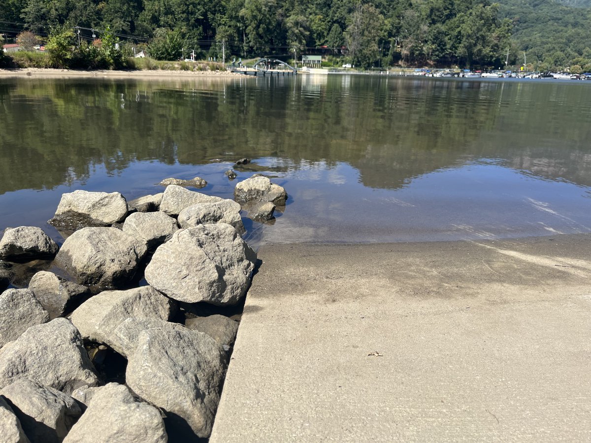 WLOS_13's tweet photo. Lake Lure is looking a little low today. It's part of the town's preparations for expected heavy rain from Ian. Leaders say the lake level was lowered an additional 3 feet in preparation for the storm. #avlnews #hurricaneian https://t.co/j5gEarH9OL https://t.co/RVTwXwHrkT