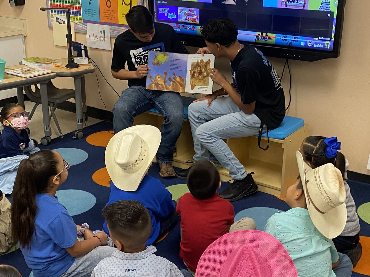 Baseball players taking some time to read to Cubs from Surratt. How many future baseball players can you see?