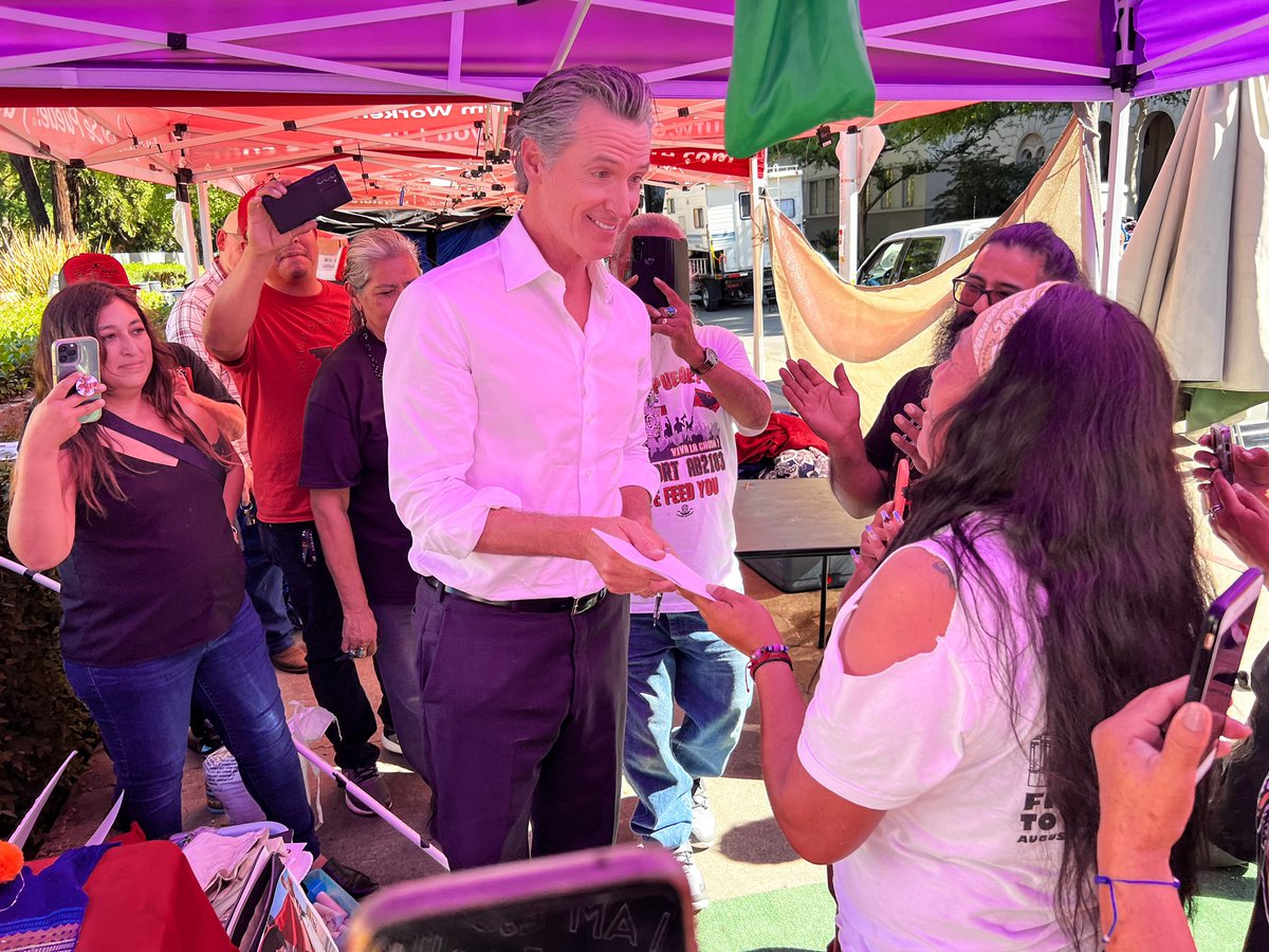 CAgovernor's tweet photo. CA’s farmworkers are the lifeblood of our state &amp; have a fundamental right to unionize and advocate for themselves in the workplace.

Alongside advocates and farmworkers outside the State Capitol, Governor @GavinNewsom signed legislation expanding union rights for farmworkers. ✊🏽 https://t.co/4J8fYa4ix7