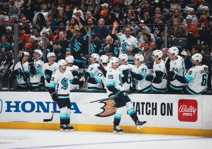 Bjorky and burky skating by bench fist bumping the boys after a kraken goal