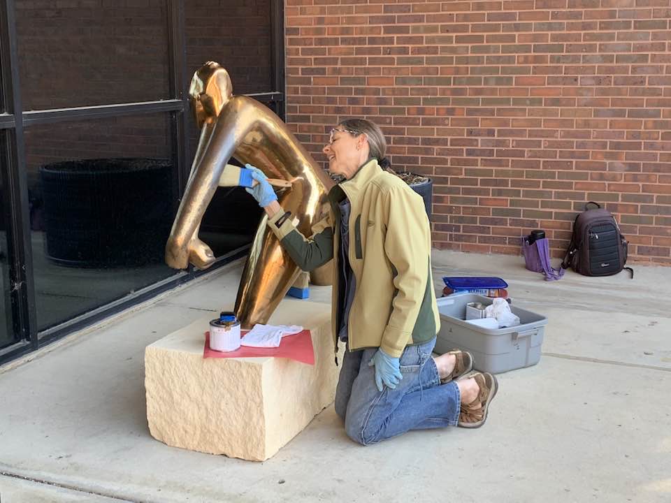 Marianne Marti, a member of the Russell-Marti Conservation Services team, works to restore the patina of Invocation by Hugo Robus, one of more than 80 works in the Martin H. Bush Outdoor Sculpture Collection at WSU. Wanna tour it? Find a map here: ulrich.wichita.edu/martin-h-bush-…