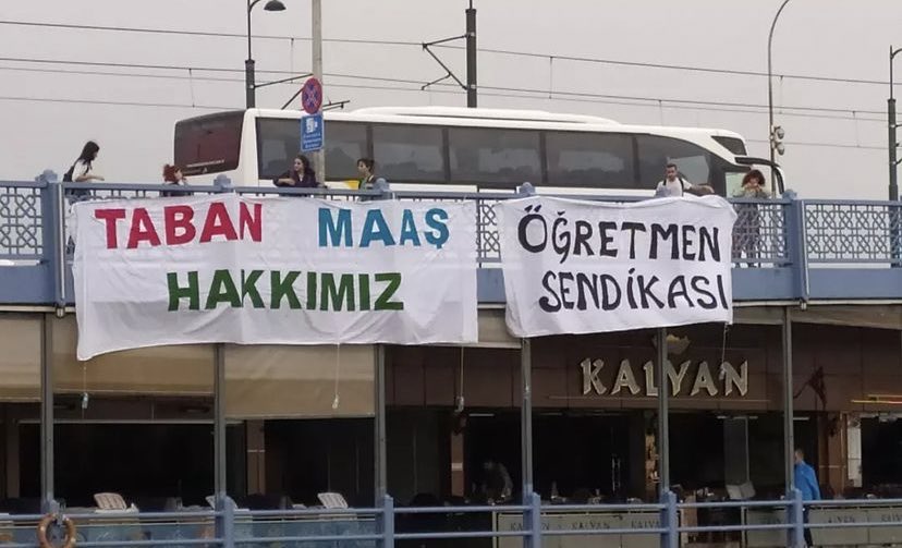 📌Özel Sektörde çalışan öğretmenler bir süredir maaşları ile ilgili düzenleme yapılması için eylemler gerçekleştiriyordu.

📌Özel Sektör Öğretmenleri Sendikası (<a href="/ogretmensendika/">Özel Sektör Öğretmenleri Sendikası</a>) Galata Köprüsü’ne Taban Maaş Hakkımız pankartı asarak taleplerini tekrar gündeme getirdi.