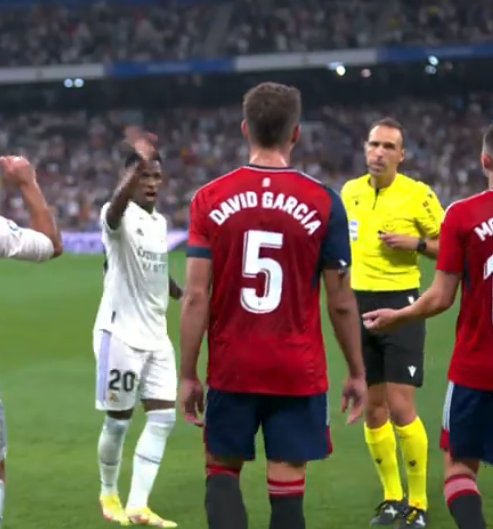 Diciéndole adiós en la roja a David García. Vinicius es un ser absolutamente despreciable.