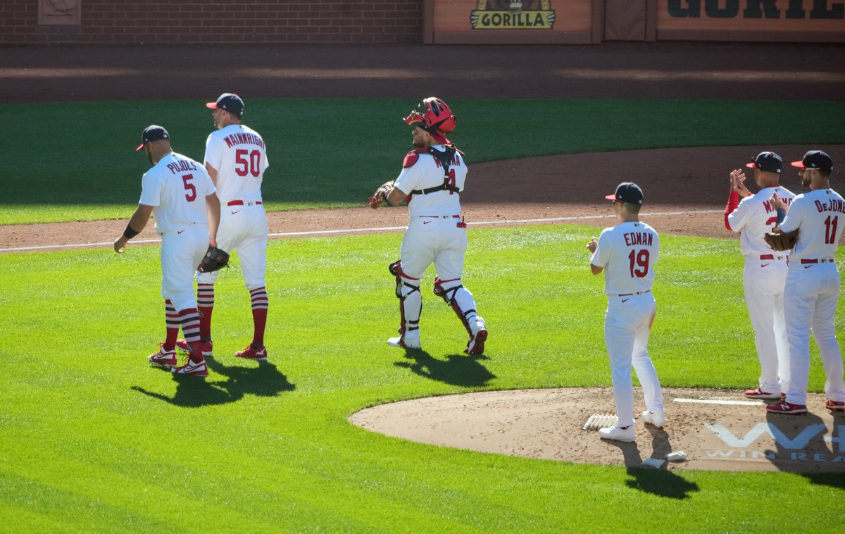 As teammates clap, St. Louis Cardinals Albert Pujols, starting pitcher Adam Wainwright and catcher Yadier Molina, leave the game together during a pitching change in the fifth inning during a game against the Pittsburgh Pirates at Busch Stadium in St. Louis on Sunday, October 2.
