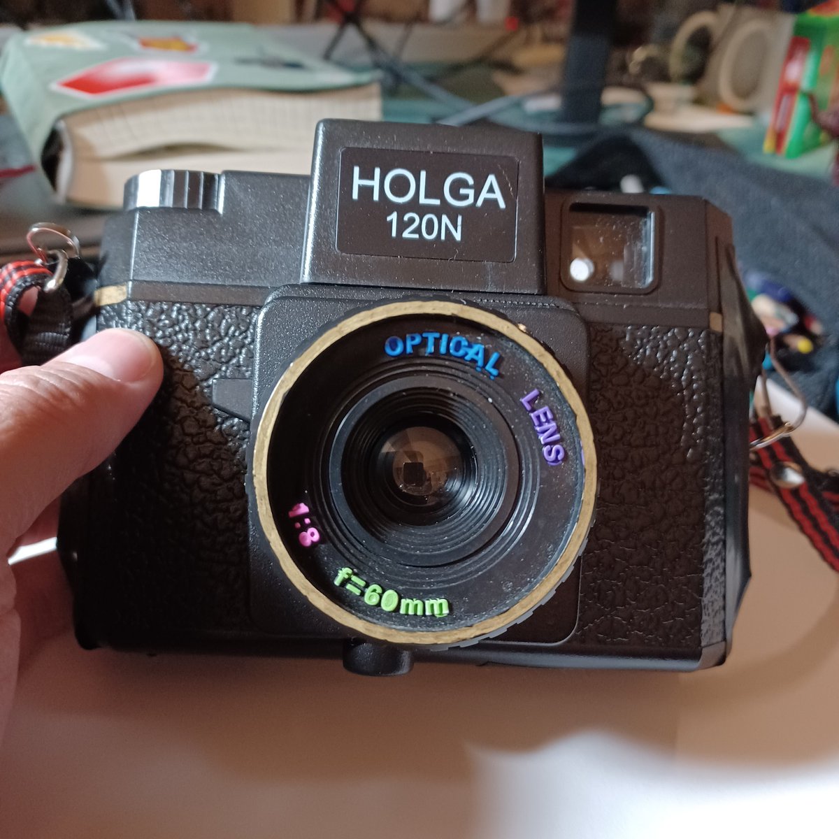 A little decoration for my camera in honor of <a href="/HolgaWeek/">Holga Week</a>. I already took 2 shots with lens cap on, it has since been taken away by @Tuttle_Facts who offered to rewind the film in the dark bag so I can try again #HolgaWeek2022