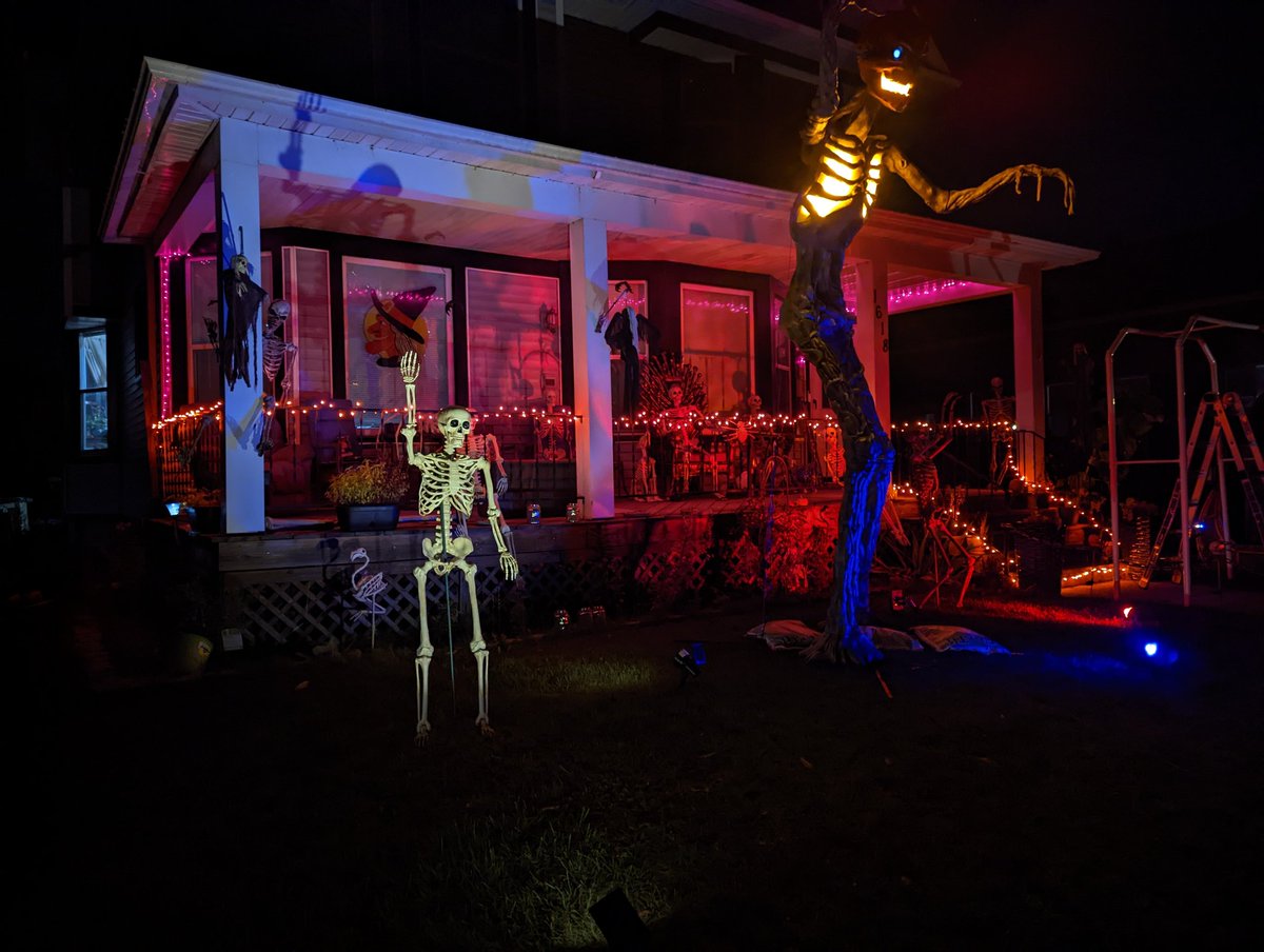 MephistoMori's tweet photo. About halfway done decorating. Still gotta get on top of my porch. Set my gravestones and cemetery fence, sling some cobwebs and more lighting around, pose more skellingtons, set up the 15 footer (who's waiting on clothes) and naturally put an 8' spider on my roof. #SpookySZN https://t.co/5GKB4yOmUy