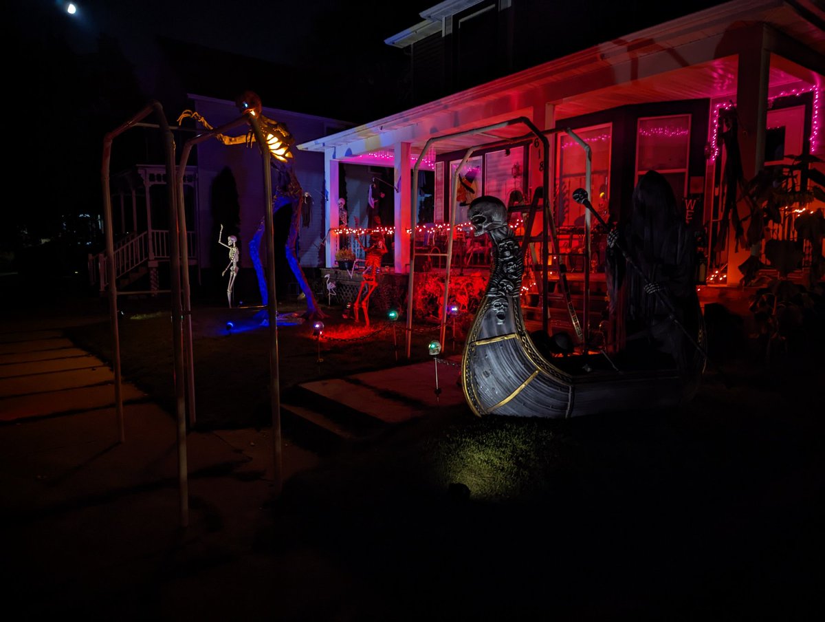 MephistoMori's tweet photo. About halfway done decorating. Still gotta get on top of my porch. Set my gravestones and cemetery fence, sling some cobwebs and more lighting around, pose more skellingtons, set up the 15 footer (who's waiting on clothes) and naturally put an 8' spider on my roof. #SpookySZN https://t.co/5GKB4yOmUy