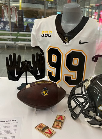 AppState_FB's tweet photo. Love seeing ⚫️ + 🟡 in the @CFBHall!

✔️ Jersey from Michael Hughes' tiebreaking FG at No. 6 Texas A&amp;M on 9/10
✔️ Pre-@CollegeGameDay visit mousetraps
✔️ Game ball and pair of Christan Horn gloves from App State's 9/17 win in which Horn scored on a game-ending Hail Mary 

#GoApp https://t.co/s4CyGVXxaQ