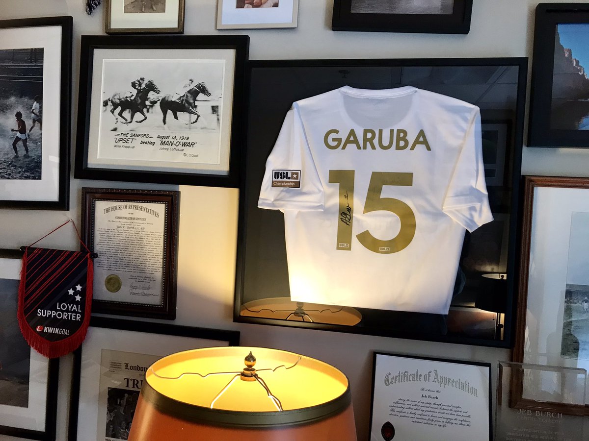 CentreSoccer's tweet photo. Finally got Garuba’s @ATLUTD jersey framed and up in office! What a shining example of what a top talent, is the hardest worker, being a team first player, can achieve! G holds 6 SAA &amp; 6 #CentreSoccer scoring records! https://t.co/RNDOa0c60O