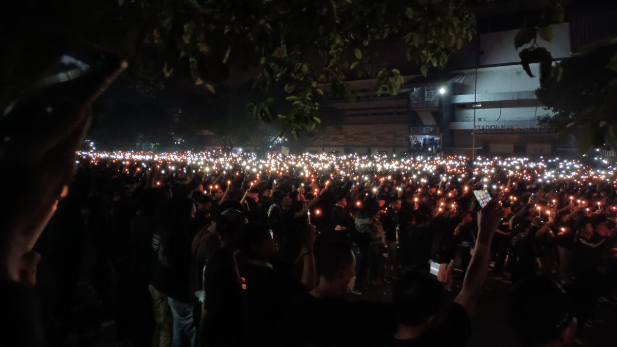 garistengah_id's tweet photo. Tadi malam, kami ikut hadir dalam doa bersama yang dihadiri oleh Brajamusti, Pasoepati, Brigata Curva Sud, dan Slemania untuk korban dari tragedi Kanjuruhan.

Beragam warna melebur jadi satu, membentuk cahaya kuning dan kobaran kecil api yang mengandung pesan: kami berduka. https://t.co/gfUjC86XrZ