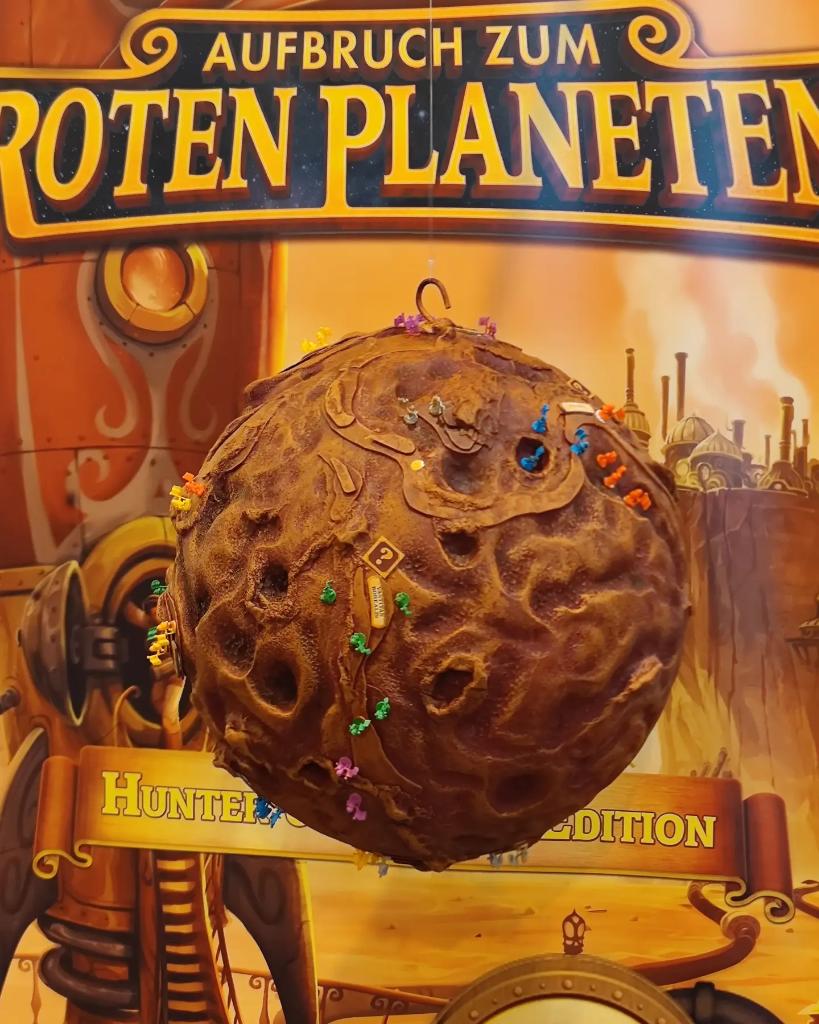 Das Geheimnis ist gelüftet. Dieses Jahr erwartet euch an unserem Stand Halle 6 J105 der "Goodie Planet". Kauft ein Aufbruch zum Roten Planeten oder etwas anderes im Wert von 60€ und zieht ein Goodie. Gewinnchance 100%. #SPIEL22