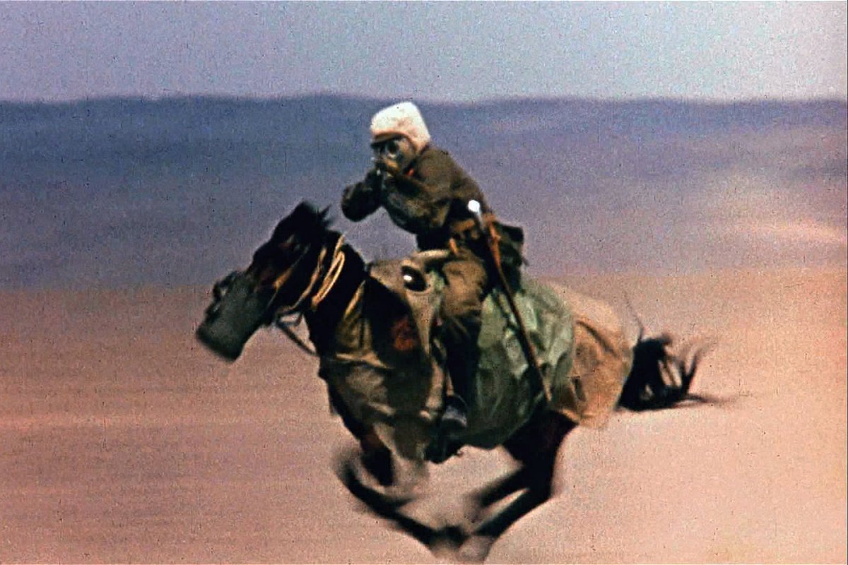 Rare shot of a soldier "aiming" at a cameraman while riding on the horse in an area of the nuclear exercise conducted by China. Lop Nur, 1960s