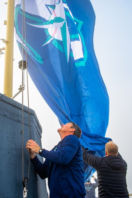 Dan Wilson raises the Mariners flag at the top of the Space Needle.