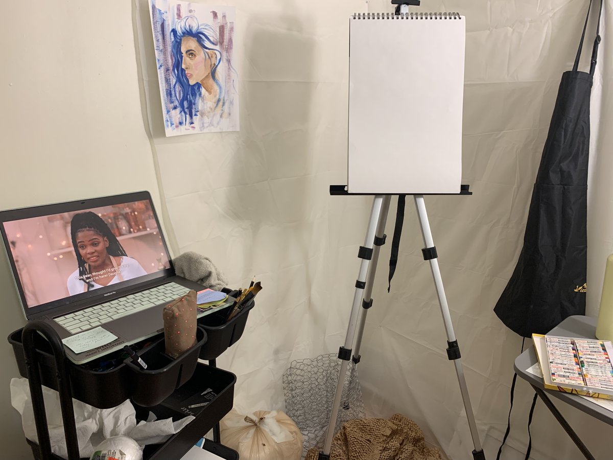 empty sketchpad on an easel while GBBO plays on a laptop and they are trying to bake their cookies
