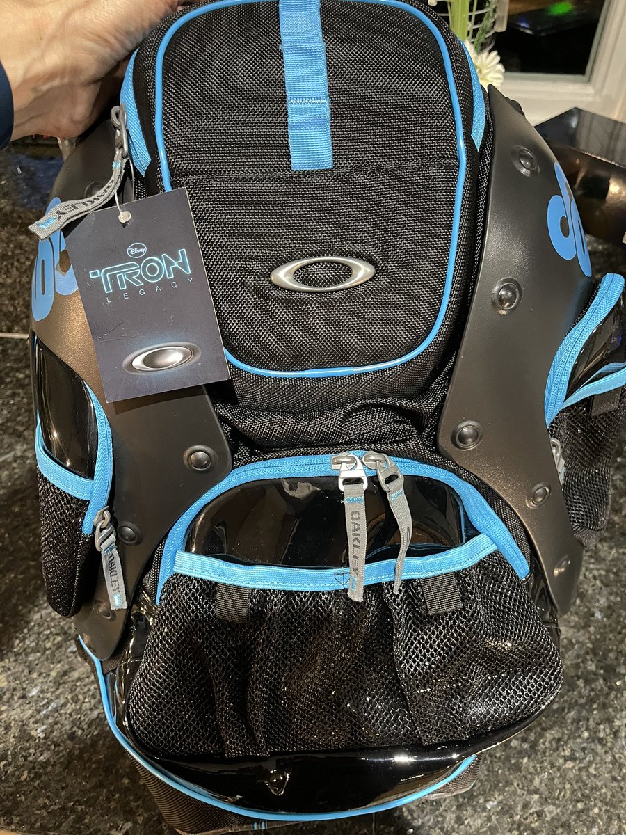 ch4os_theory's tweet photo. Loungefly Tron 40th anniversary mini backpack pictured with the Oakley Tron Legacy backpack from 2010. The ‘data disc’ on the back lights up #tron #tronlegacy #loungefly #myfirstloungefly #Disney #tron40 #oakley https://t.co/vtkevq8L0o