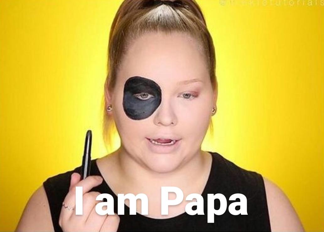 Nikkie tutorials screenshot, she's doing skull makeup, she has done just her right eye, just that, she's holding a black eyeliner crayon, there's a text in the bottom that says "I am papa" 