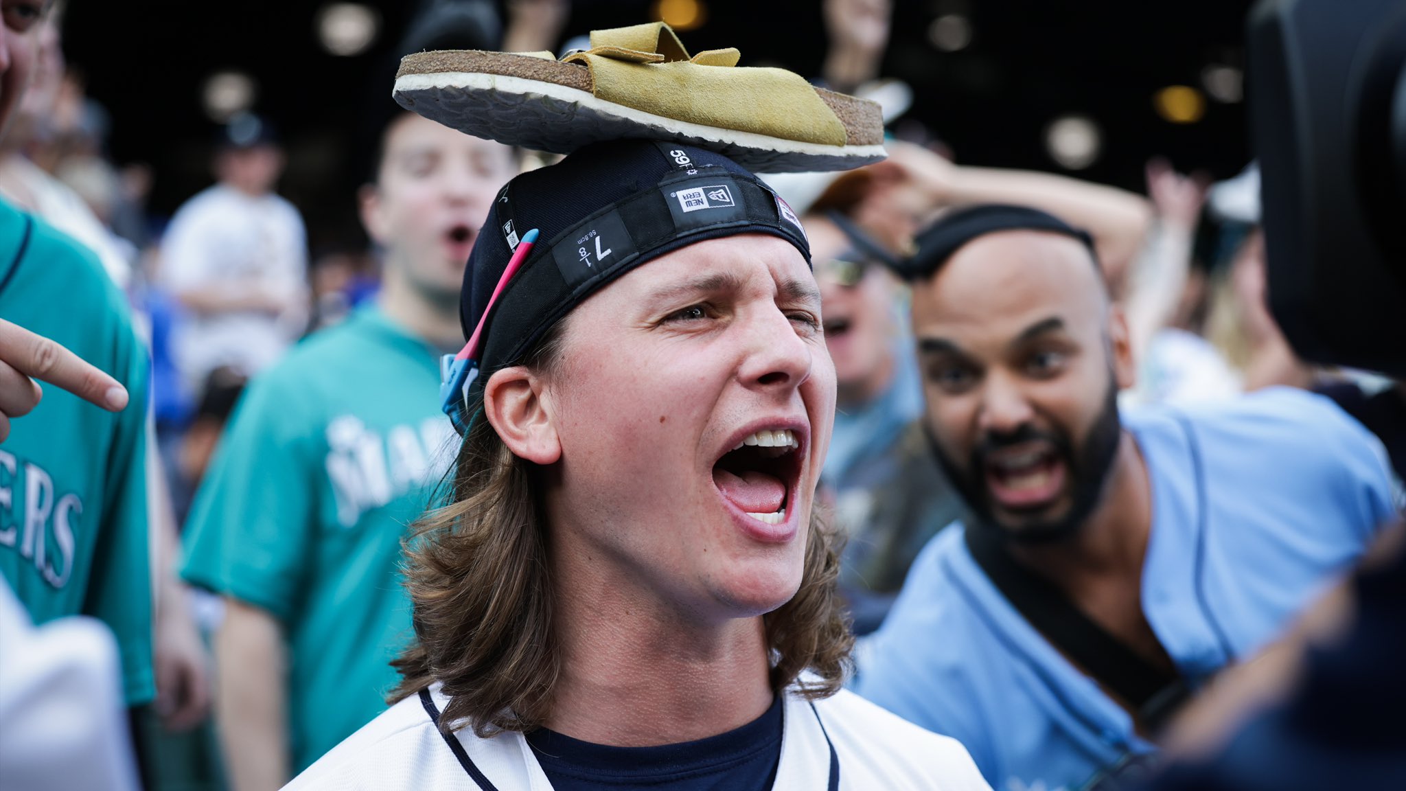 Mariners fan Ben Cox cheers with his wife’s show balanced on his head.