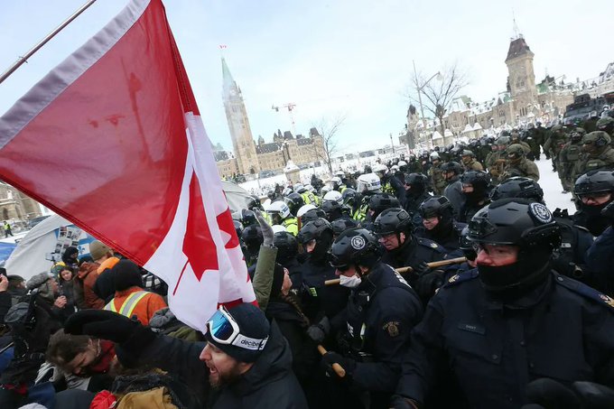 Protesters from the so-called "Freedom Convoy" are moved from Wellington Street in front of Parliament Hill in Ottawa by police officers on Feb. 19, 2022.