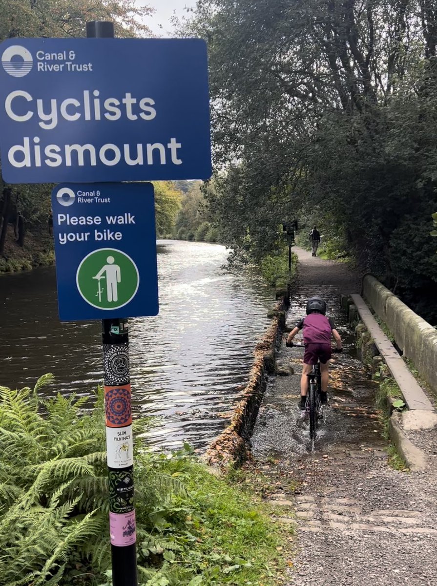 Confused by the new signs on the weir on Rochdale canal?How does a child walk their bike here-you cant fit a person and a bike on the bridge?Their arms aren't long enough to walk on the bridge &amp; push the bike through the weir?Are they meant to get wet feet? <a href="/CanalRiverTrust/">Canal & River Trust</a>