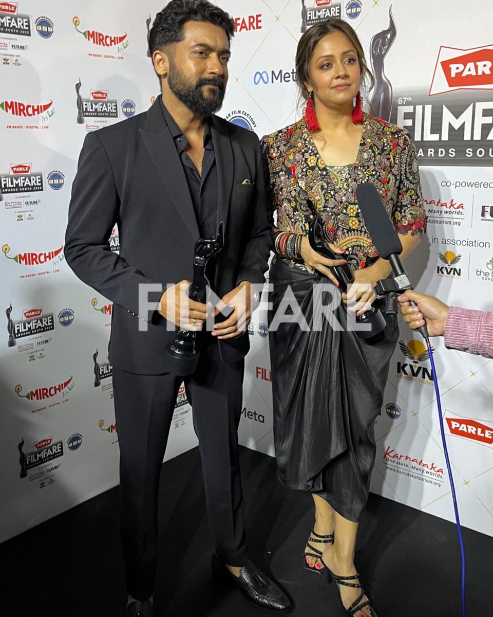 filmfare's tweet photo. Stars, stars, stars all around!

#Suriya and #Jyothika pose backstage at the 67th #ParleFilmfareAwardsSouth 2022 with Kamar Film Factory.
⭐️💓 https://t.co/GqUb35Dbxi