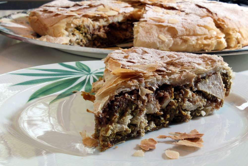 Chicken Bastilla is a traditional Maghrebian pie filled with chicken, scrambled eggs, and a crunchy layer of sweet cinnamon toasted almonds, all wrapped up in buttery phyllo pastry. Recipe cultureatz.com/chicken-bastil… #eattheworld #moroccanfood #internationalcuisine #cultureatz