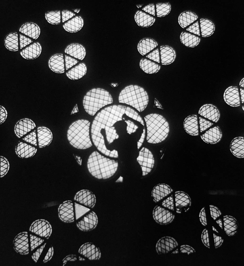 French photographer Roger-Viollet Backlit worker and rose window at Notre-Dame de Paris cathedral Paris, circa 1935
