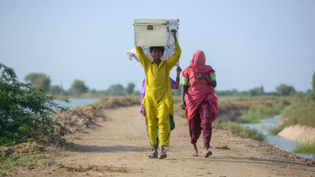 Aksh, 35 (in yellow), walks to find shelter after floods displaced him and his family in Jamshoro, Pakistan. Half a million people are now living in temporary shelters in relief camps. DEC charities are supporting them, but more help is needed. bit.ly/DECPakistanFlo…