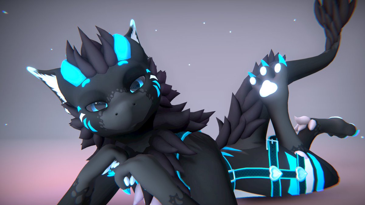 Dark grey with blue accent Nardoragon looking at the camera while laying down on their stomach with their hands up to their chin and a smug expression on their face.
