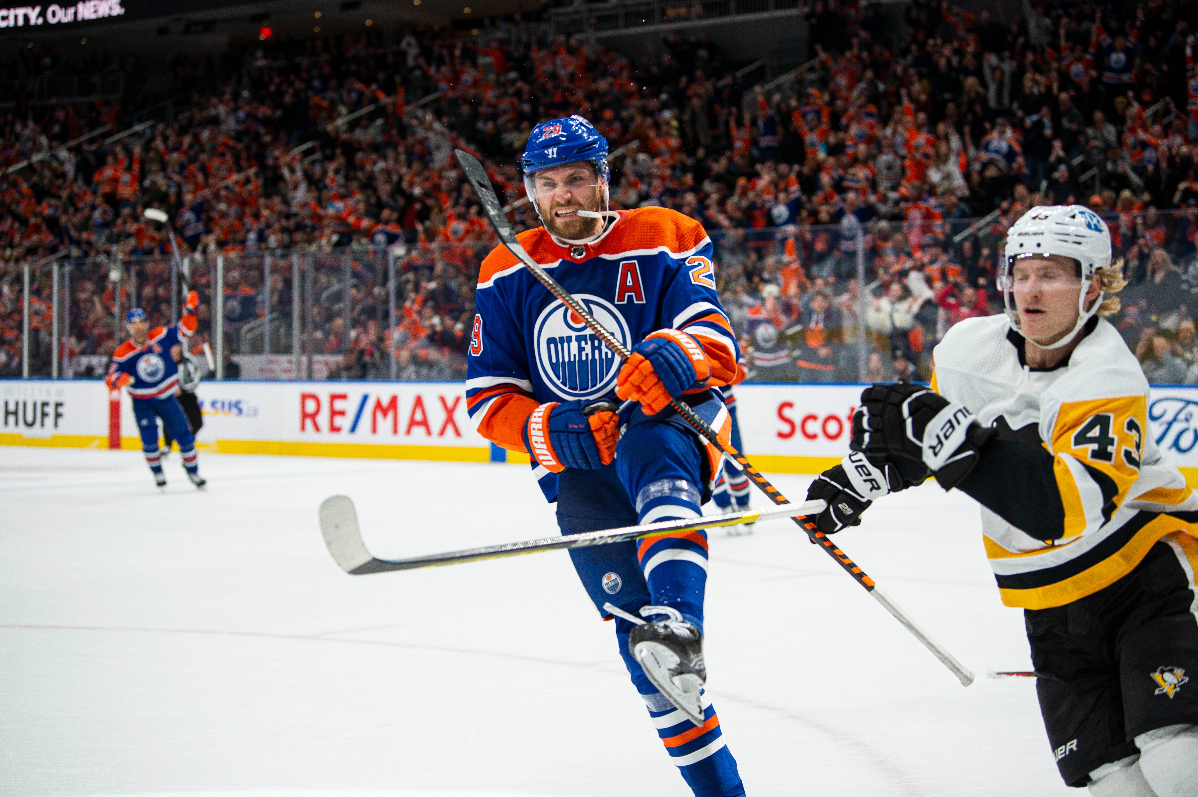 Leon Draisaitl on ice celebrating a goal in an Edmonton Oilers home uniform. 