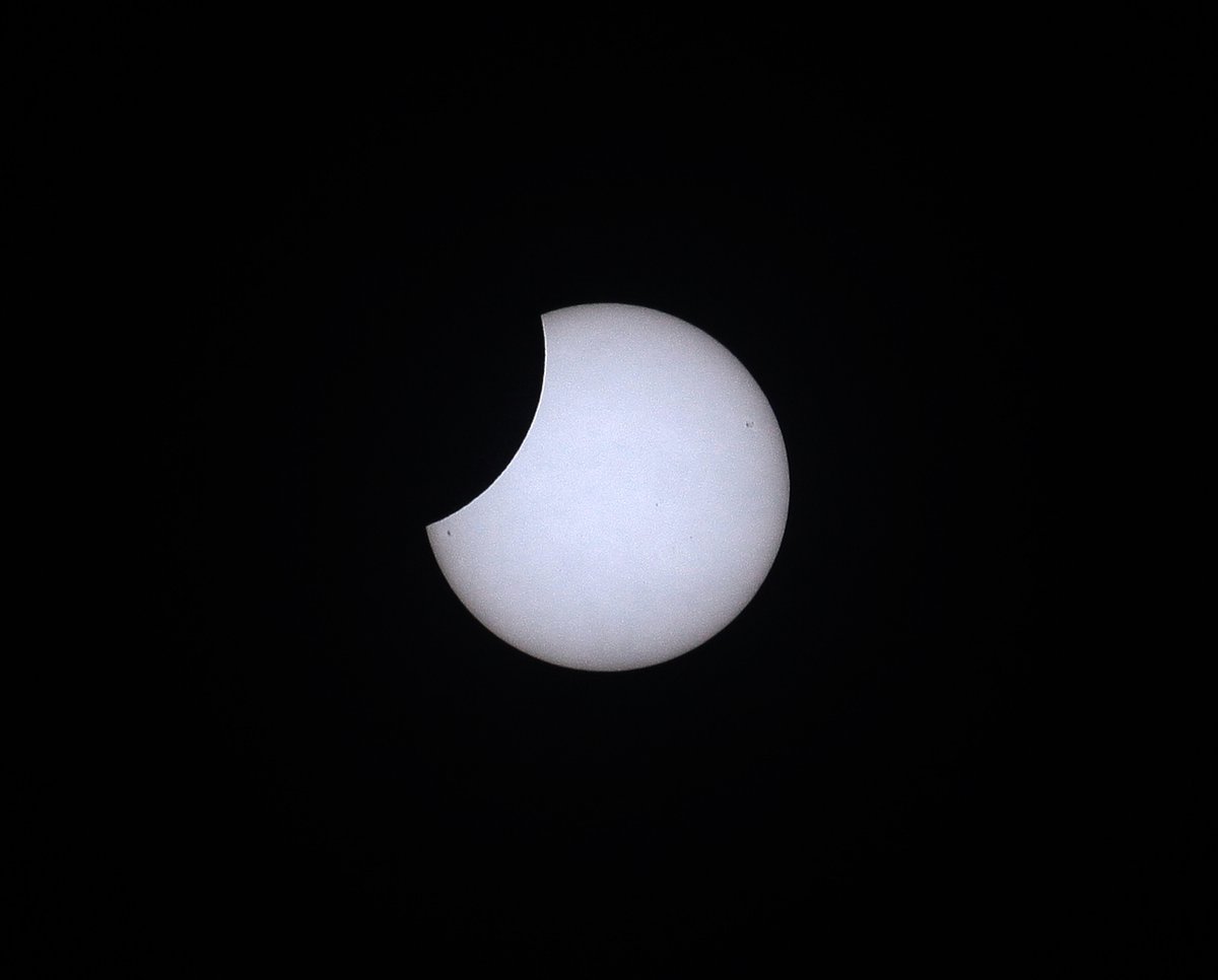 Couple of quick shots of the #Eclipse2022 ... one through trees (and passing aircraft), and one with sunspots