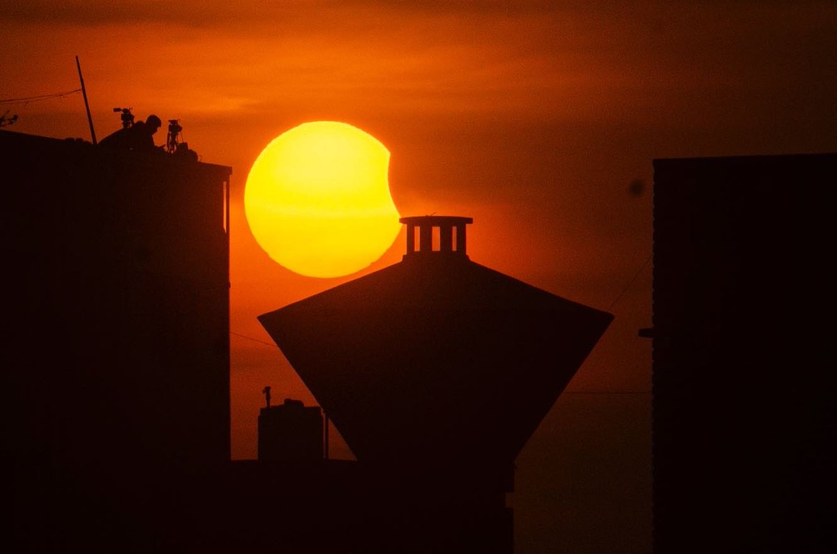 Media personnel stand atop a building as the moon partially covers the sun during a partial #solareclipse, at #Marinabeach, in #Chennai, #India, 25 October 2022. EPA-EFE/IDREES MOHAMMED #epaphotos #solareclipse2022 #sun #moon #tamilnadu #madras