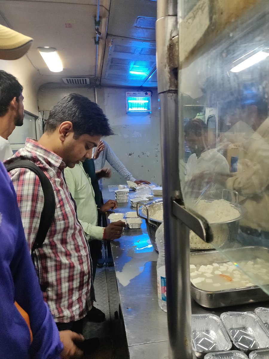 unikarvind's tweet photo. Passengers in queue to get food in pantry car around 11 in Rajdhani Clone 02250 with costly fare. Childrens, ladies, elders are hungry and hopeless. Is this new india who struggle for food @PMOIndia @IRCTCofficial @RailMinIndia @PiyushGoyal https://t.co/cRZeIgeGNH