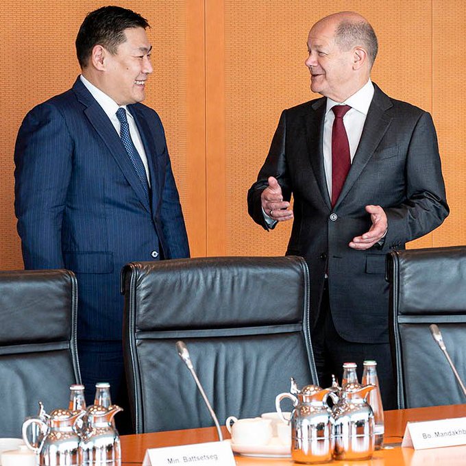 Bundeskanzler Scholz und der Premierminister der Mongolei, Luvsannamsrain Oyun-Erdene unterhalten sich lächelnd vor einem Konferenztisch im Kanzleramt.