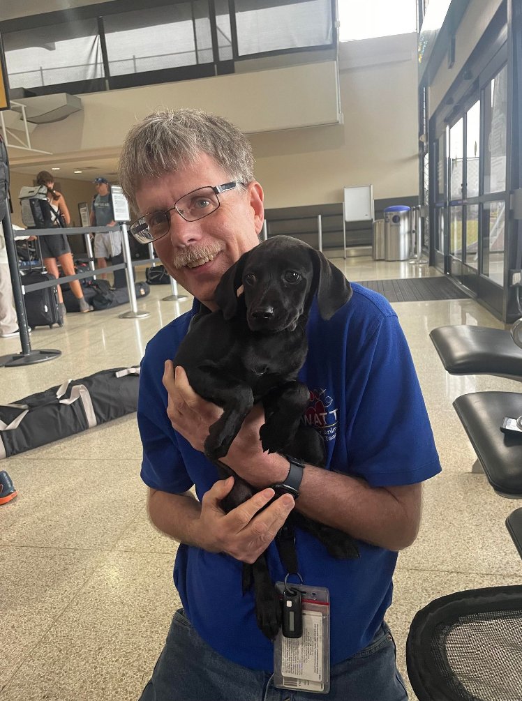 Thomas R. posing for a photo with a dog. 