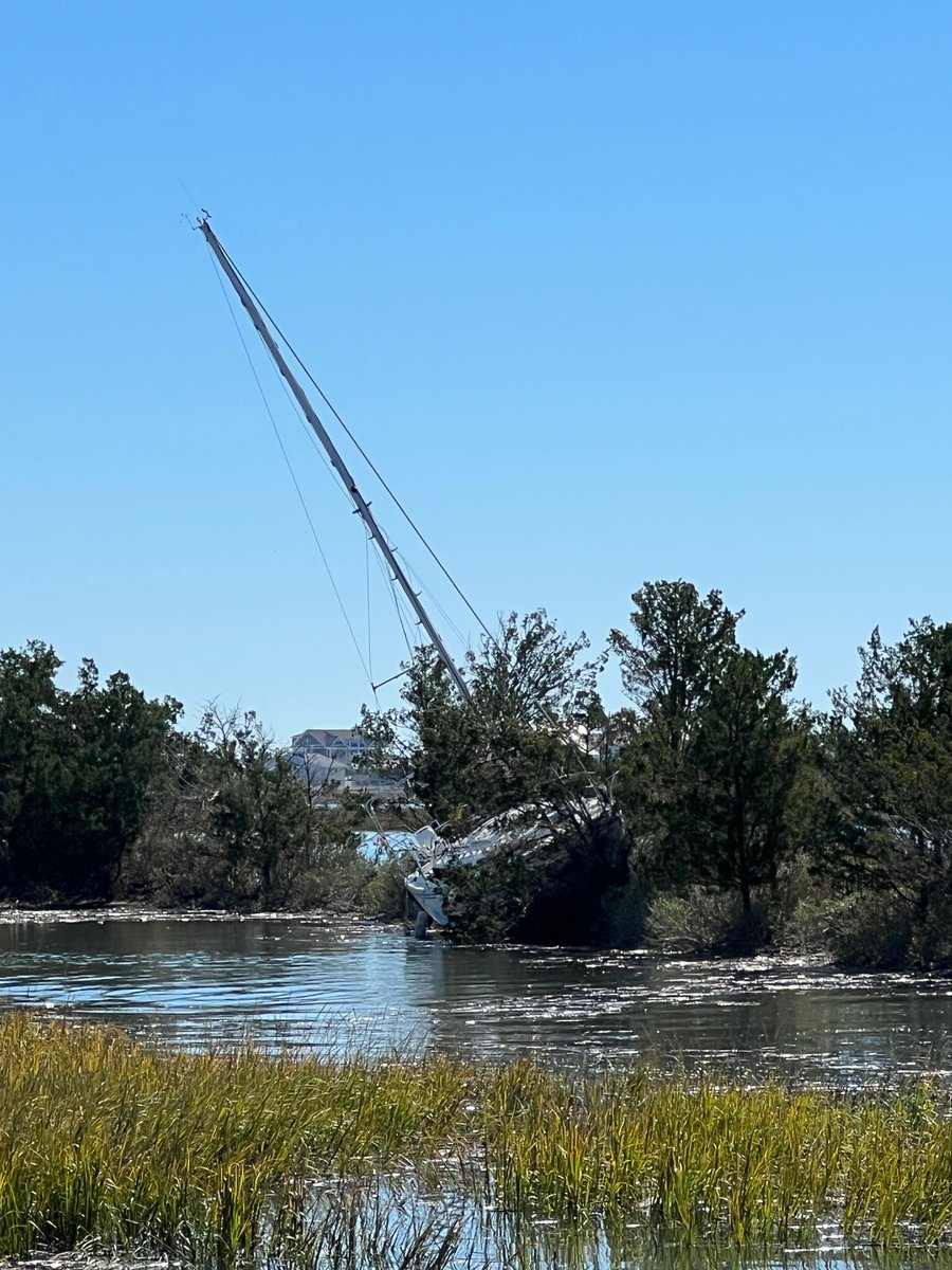 CarmenandBrian's tweet photo. Sail boat up on one of the islands at Murrells inlet marsh walk from hurricane Ian. #murrellsinlet #marshwalk https://t.co/L8uhiyyiAX